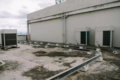 Rooftop air conditioning units with structural support and urban skyline Stock Photos