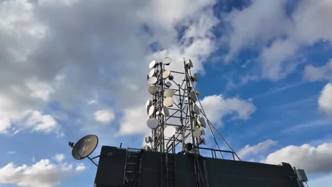 Rooftop Base Station and Antennas Timelapse with Fast-Moving Clouds Stock Footage 321294327