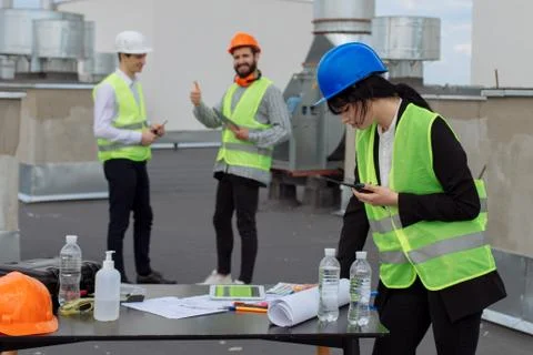 On the rooftop of construction site beautiful engineer make a conversation with Foto stock
