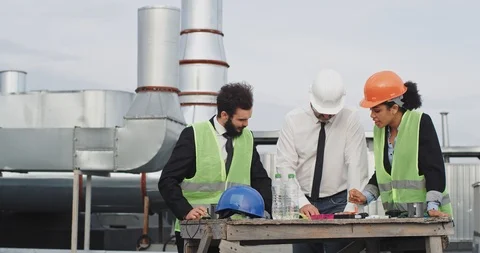 Rooftop of construction site two engineers and one architect multi ethnic Stock Footage 116408647