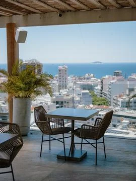 Rooftop dining area with ocean view in urban coastal setting Stock Photos