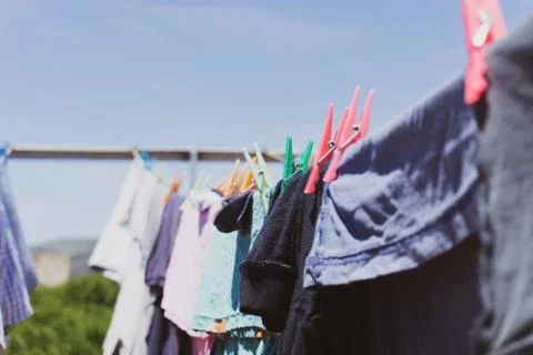 Rooftop drying line full of fresh clean clothes under a blue sky. Stock Photos