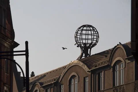 Rooftop Globe Sculpture on Classical Building with Birds in Flight Stock Photos