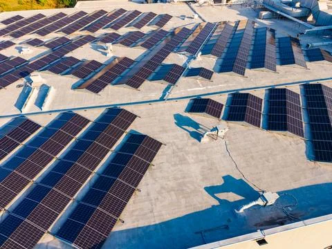 The rooftop has many solar panels arranged across the surface. The panels are Stock Photos