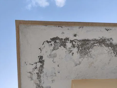 Rooftop paint peeling due to rain and water damage with sky visible in the .. Stock Photos