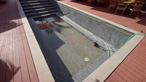 Rooftop Pool Deck with Drainage Hose and Water Reflections Stock Footage 344370871