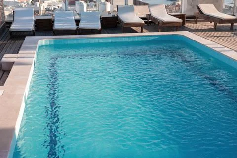 Rooftop pool with lounge chairs overlooking cityscape Stock Photos