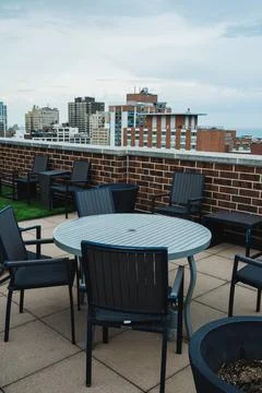 Rooftop seating area with tables and chairs overlooking the city skyline on.. 写真素材