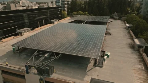 Rooftop solar energy array powering hydrogen plant captured by backward flying Stock Footage 334248763