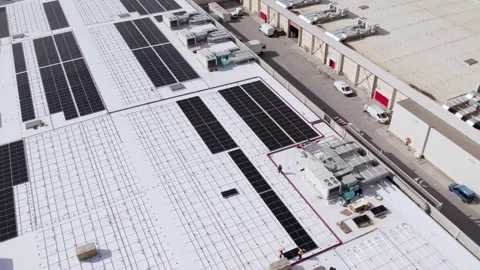 Rooftop solar farm under construction with workers revealing panels aerial Vídeos de archivo 331127040