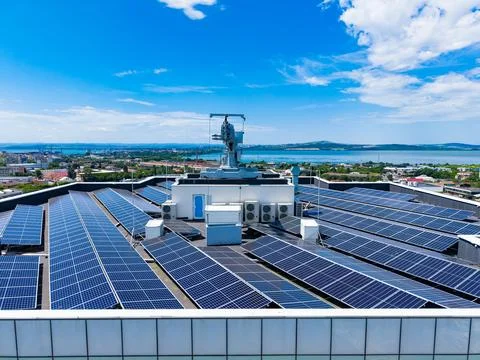 Rooftop solar panel installation in an urban area during the day with blue .. Stock Photos
