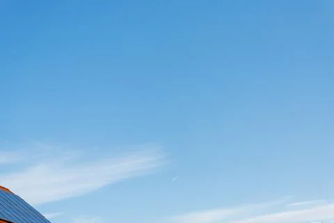 Rooftop solar panels generating clean energy under blue sky Stock Photos