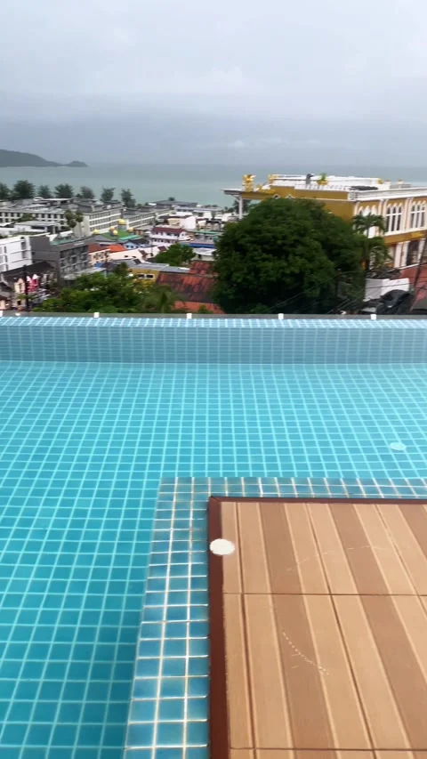 Rooftop swimming pool with blue tiles and wooden deck Stock Footage 330767581