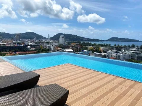 Rooftop swimming pool with infinity edge overlooking cityscape and mountains Photos