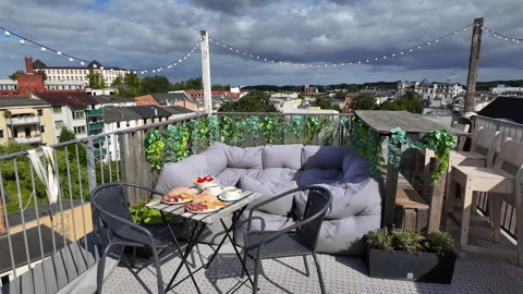 Rooftop terrace breakfast with coffee, pastries, panoramic city view in Rostock. Video stock 344880737