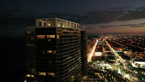 Rooftop terrace glowing above the evening street in Bal Harbour, Florida Video stock 100096854