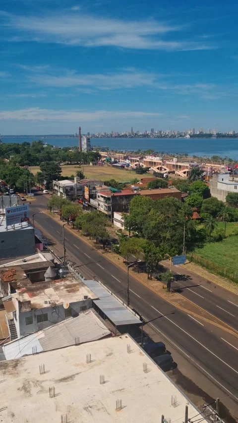 Rooftop vertical shot over Encarnación with views across the Paraná River to Video stock 337223339