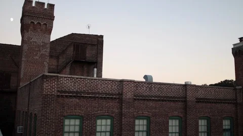 Rooftop view of brick building at dusk 스톡 동영상 97094906