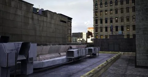 Rooftop view of city buildings under cloudy sky during late afternoon Ilustración de archivo