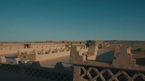 Rooftop view over mud brick kasbah walls and desert town under blue sky Morocco Stock Footage 334514429