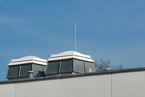 Rooftop view of skylights on building under blue sky Foto stock