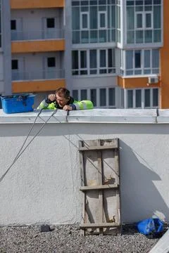 A Rooftop Worker: Skilled Technician Performing Maintenance on a Building Roof Stock Photos