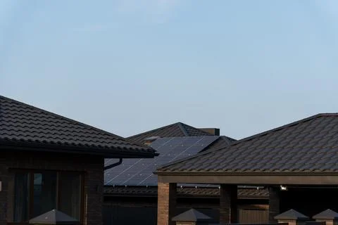 Rooftops adorned with solar panels stretch across a peaceful neighborhood. Фото