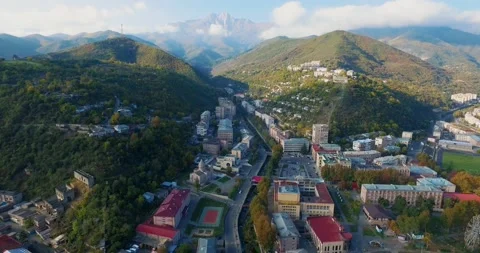Rooftops and roads moving towards the green forest mountain Stock-Footage 131739721