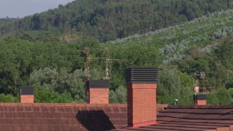 Rooftops with chimneys and antennas overlooking Basque Country forest Vídeos de archivo 341839020