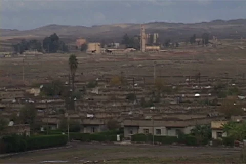 Rooftops of homes with oil facility and Zagros mountains in distance. Stock Footage 86753316