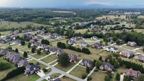 Rooftops of a large lot subdivision spread across rolling Virginia countryside Stock Footage 345684116