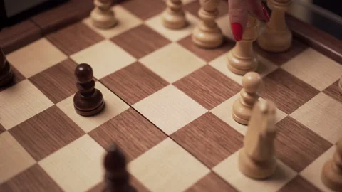 Rook devouring a wooden chess pawn, angled close up Stock Footage 262443137