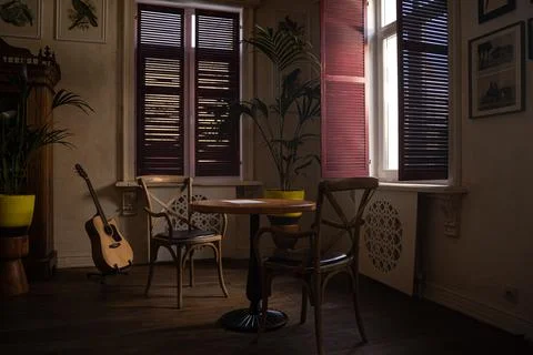 A room with a couch and table in front of a window Stock Photos