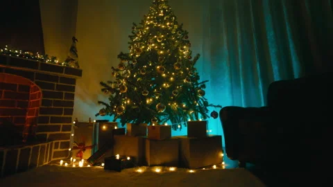 Room decorated with a Christmas tree and gift packages at night Stock Footage 320393427