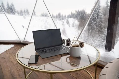 Room interior with panoramic windows. Table with laptop, phone and cup of tea Stock Photos