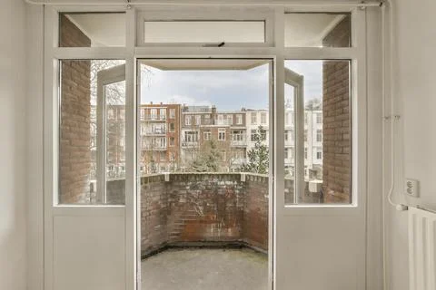 A room with a large window and a brick wall Stock Photos