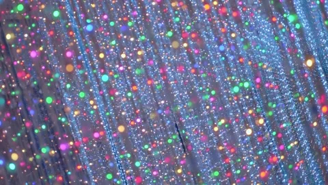 A room with mirror walls full of vertically hanging multicolor LED light stripes Stock Footage 333340196