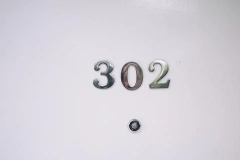 Room number on white door with cat eye Stock Photos