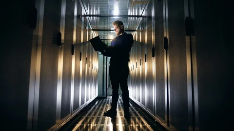 Room with server units and a man operating a laptop Stock Footage 111291416