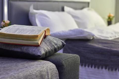 In the room there is an open book on the edge of the sofa Stock Photos
