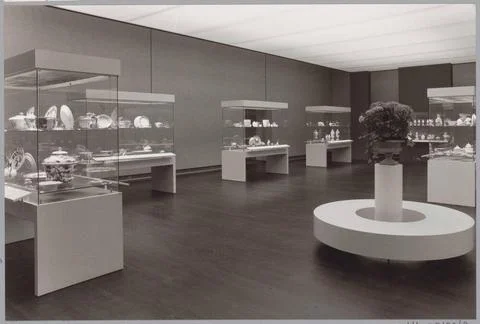 Room with various objects in showcases, in the foreground a round bank for... Stock Photos