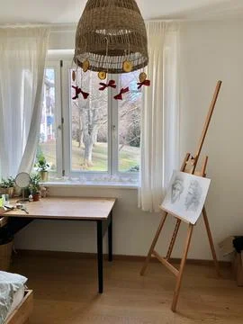 Room with window easel with artwork table chair Stock Photos