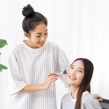 Roommates have fun learning to make-up for asian friends Stock Photos