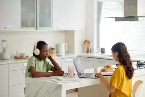 Roommates Studying in Kitchen Stock Photos