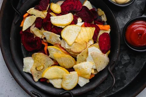 Root Vegetable Crisps, on gray stone table background, top view flat lay Stock Photos