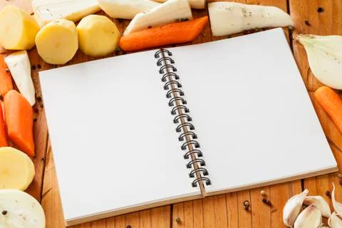 Root vegetables and notebook for your recipe. Stock Photos