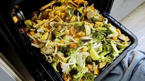 Root vegetables potato broccoli carrot steaming hot from the oven cooked Stock Footage 273774100