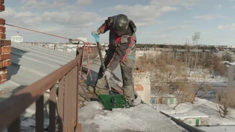 Rope access specialist to remove snow and ice from the roof of the house Stock Footage 235896231