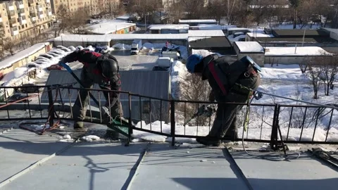 Rope access specialist to remove snow and ice from the roof of the house Stock Footage 235899165