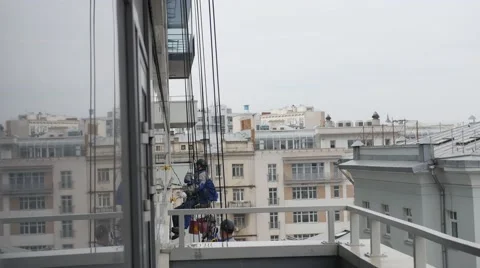 Rope access specialists cleaning facade windows. City buildings in the Stock Footage 63504658